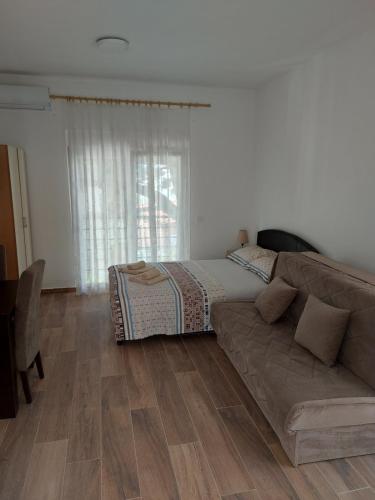a living room with a couch and a bed at Crni Bor Sutomore in Sutomore