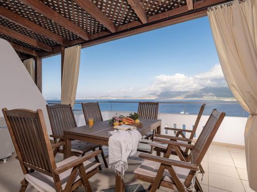 a table and chairs on a balcony with a view of the ocean at Porto Kaza in Sitia