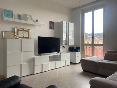 uma sala de estar com uma televisão de ecrã plano e um sofá em Casa vacanza Le Cinque Terre em La Spezia