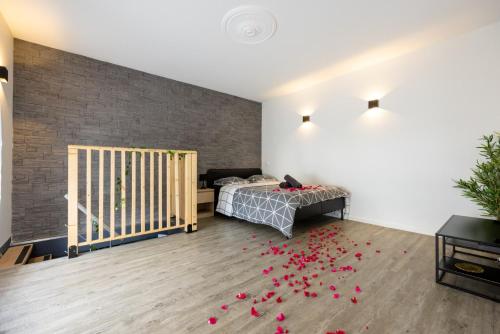 a bedroom with a bed and red petals on the floor at Cosy Room Jacuzzi Romantique in Nantes