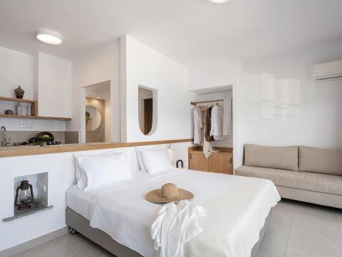 a white bedroom with a bed with a hat on it at Porto Kaza in Sitia