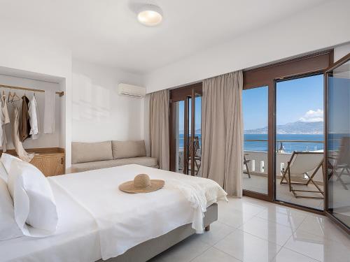 a bedroom with a bed and a view of the ocean at Porto Kaza in Sitia