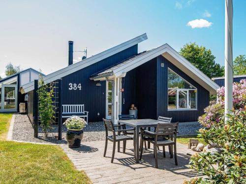 eine Terrasse mit einem Tisch und Stühlen vor einem Haus in der Unterkunft 6 person holiday home in Ulfborg in Vang