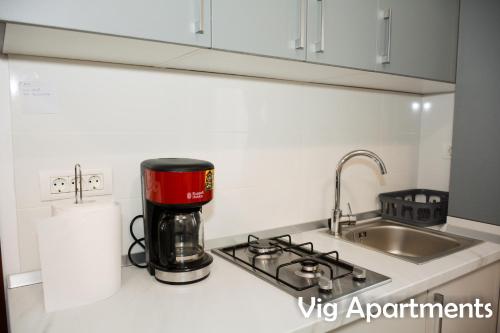 a kitchen counter with a coffee maker and a sink at Vig Apartments in Timişoara