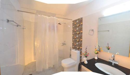 a bathroom with a toilet and a sink and a shower at Hotel Leh Residency -Leh in Leh