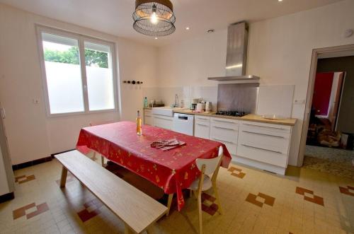 une cuisine avec une table et un chiffon rouge dans l'établissement La grande maison de Suzanne et son Jardin, à Albi