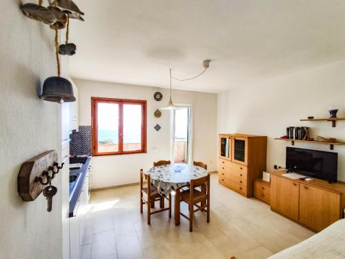 Appartamento Bellavista في كافو: مطبخ وغرفة طعام مع طاولة وكراسي