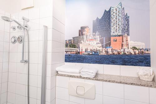 a bathroom with a shower with a view of the city at Hotel Hanseport Hamburg in Hamburg