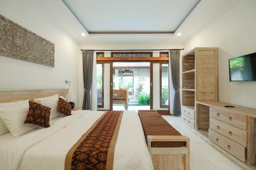 a bedroom with a large bed and a tv at Pondok Sebali Private Villa in Ubud