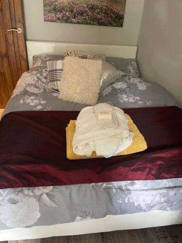 a bed with a white bag sitting on it at South Lodge House in Dormans Land