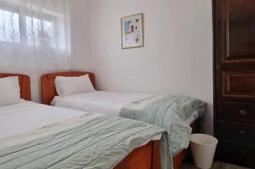 1 dormitorio con 2 camas y ventana en Casa Rosylu, en Ferragudo