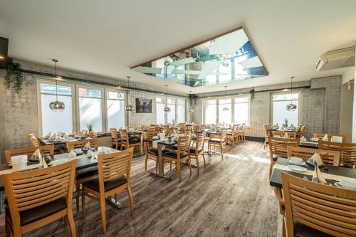 a restaurant with tables and chairs and a large window at Hotel Hanseport Hamburg in Hamburg