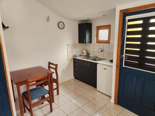 eine Küche mit einem Tisch, einem Tisch und einer Tür in der Unterkunft Pension Lale in Peštani