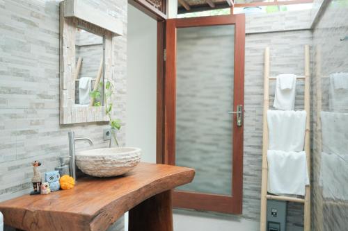 a bathroom with a wooden counter with a sink at Pondok Sebali Private Villa in Ubud