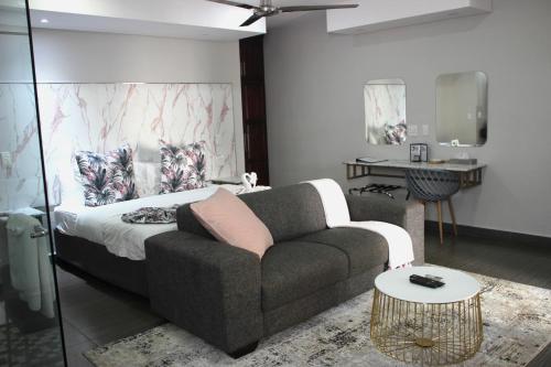 uma sala de estar com um sofá e uma mesa em Ecolux Boutique Hotel em Komatipoort