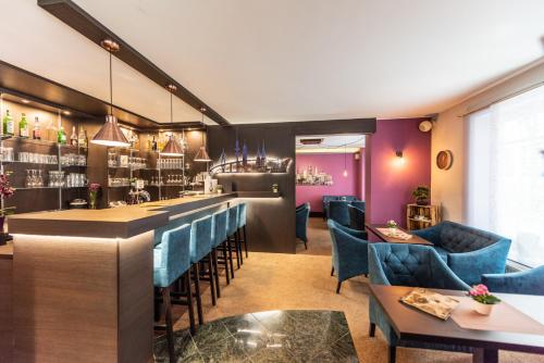 a restaurant with blue chairs and a bar at Hotel Hanseport Hamburg in Hamburg
