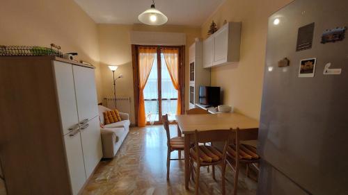 eine Küche und ein Esszimmer mit einem Tisch und einem Kühlschrank in der Unterkunft AlbengaMare in Albenga