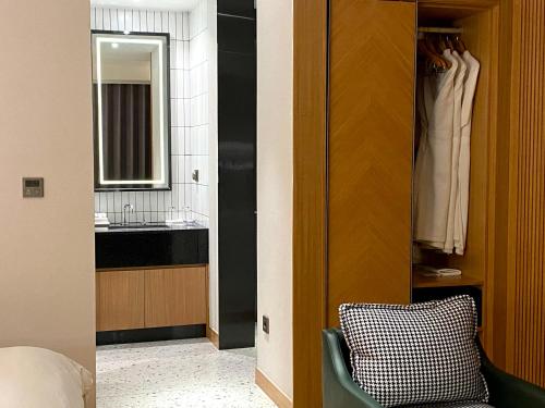 La salle de bains est pourvue d'un lavabo, d'un miroir et d'une chaise. dans l'établissement Hotel Avenue, à Changwon