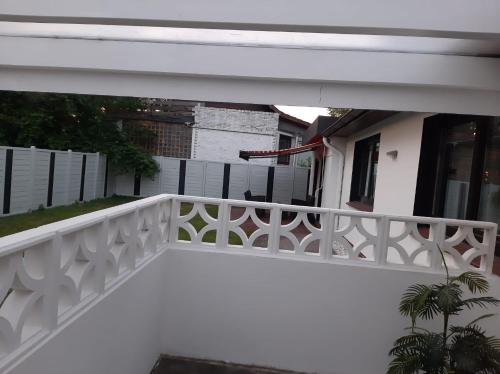 a white balcony with a white railing in front of a house at Harmonie, an der Nordküste in Nordenham