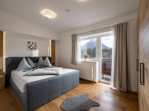 a bedroom with a bed and a large window at Appartement Mayrl in Fieberbrunn