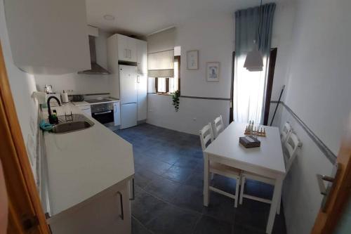 cocina con encimera blanca y mesa pequeña en Apartamentos Entreteatros, fantástico duplex casco histórico, en Talavera de la Reina