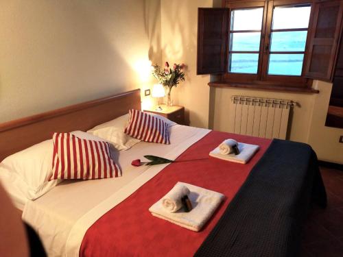 a bedroom with a bed with towels and a window at Villa Panorama in Montecatini Val di Cecina