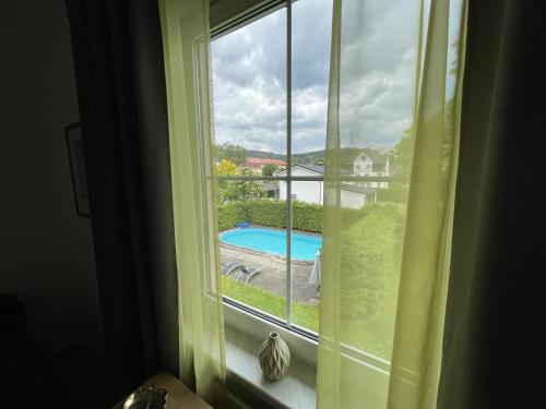 ein Fenster mit Poolblick in der Unterkunft Villa Anzio in Marienbad