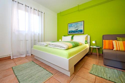 a green bedroom with a bed and a chair at Apartments Erik B&B Adults only in Rovinj