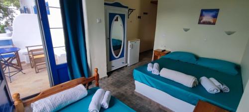 a bedroom with a blue bed and a mirror at Milisia Rooms in Samothraki