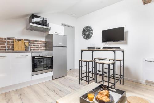 une cuisine avec des appareils blancs et une table avec un plateau de nourriture dans l'établissement Gambetta401 CahorsCityStay, à Cahors