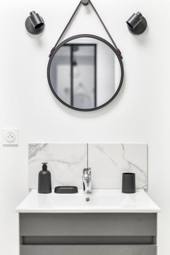 La salle de bains est pourvue d'un miroir au-dessus d'un lavabo. dans l'établissement Gambetta401 CahorsCityStay, à Cahors