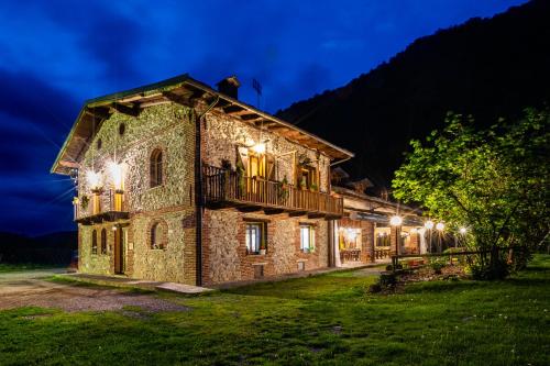 an old stone house with a man on the roof at night at Cascina Veja in Chiusa di Pesio