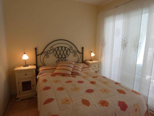 une chambre avec un lit avec deux tables de nuit et deux lampes dans l'établissement Appartement proche de la mer et du port Pays Basque Hendaye, à Hendaye