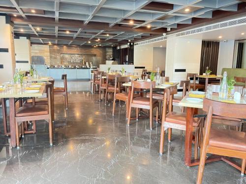a dining room with wooden tables and chairs at Paradigm Sarovar Portico in Kākināda