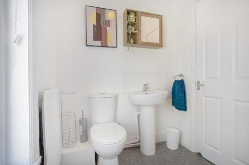 Baño blanco con aseo y lavamanos en Stylish 3-Bedroom Oasis in Darlington, Sleeps 5 en Darlington