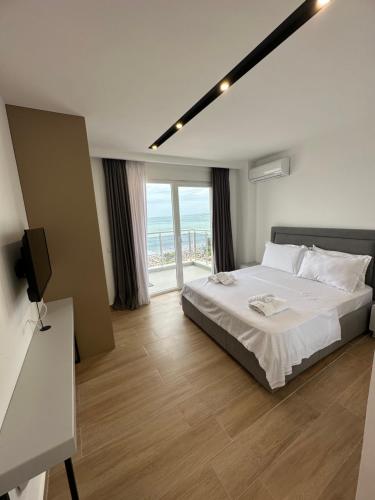 a bedroom with a large bed and a large window at Suite Hotel in Shëngjin