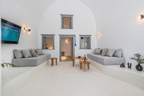 a living room with two couches and a table at Villa Paradeisos Karterados in Karterados
