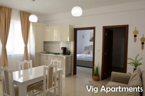 uma cozinha e sala de estar com mesa e cadeiras em Vig Apartments em Timisoara