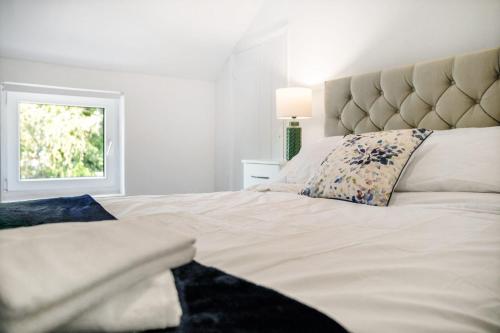 a bedroom with a large white bed with a window at Inviting 2-Bedroom Home in Coxhoe, Sleeps 4 in Coxhoe