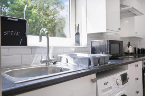 a kitchen counter with a sink and a microwave at Inviting 2-Bedroom Home in Coxhoe, Sleeps 4 in Coxhoe