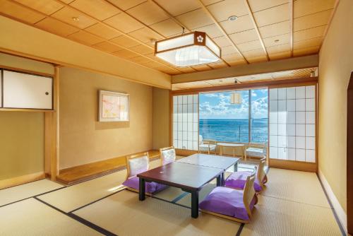 a dining room with a table and chairs at Inatori Ginsuiso in Higashiizu