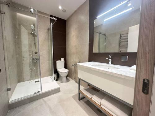 ein Bad mit einem Waschbecken, einer Dusche und einem WC in der Unterkunft Apart Hotel Istaravshan in Taschkent