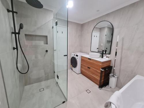 a bathroom with a shower and a sink and a mirror at West Beach Lagoon 114 – Ocean Views in Perth