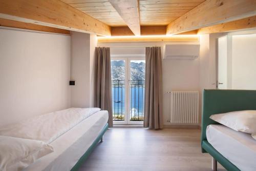 - une chambre avec 2 lits et une grande fenêtre dans l'établissement Il Frantoio a Monte-vicino al lago, à Malcesine