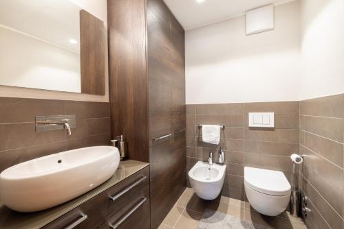 a bathroom with a white sink and a toilet at Au Reduit 106 in St. Moritz