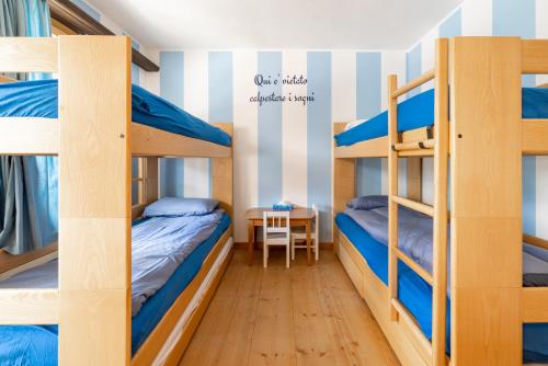a room with three bunk beds and a desk at Au Reduit 106 in St. Moritz