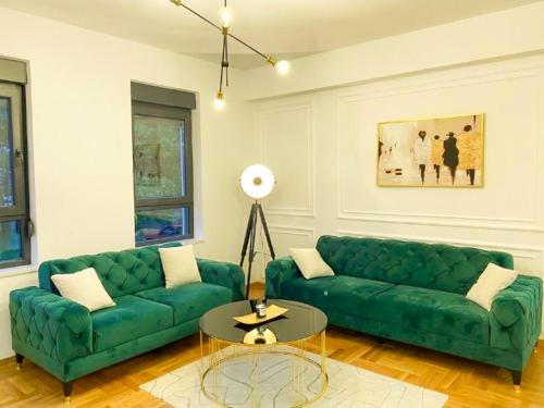 sala de estar con sofá verde y mesa en Apartman Barocco en Trebinje