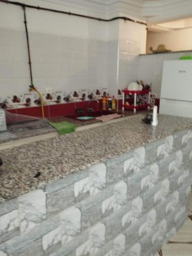 um quarto com uma parede de tijolos e uma mesa em Residence Tazoumbirt em Tigzirt