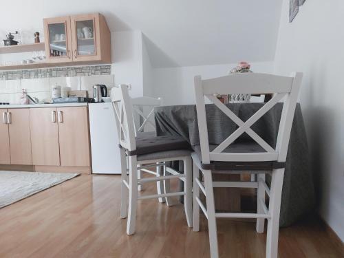 una cocina con 2 sillas y una mesa y una cocina con encimera en Apartman Čardak, en Gospić