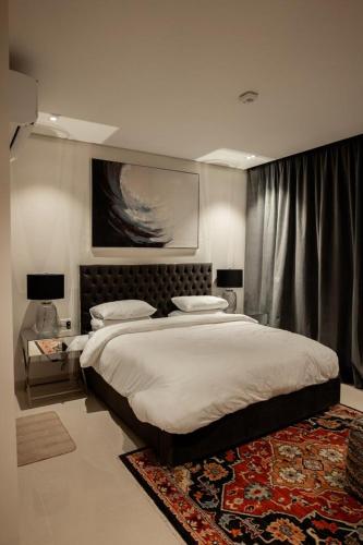 a bedroom with a large bed and a rug at Night Moon Villa JEBEL SIFA ,BF-109 in Muscat
